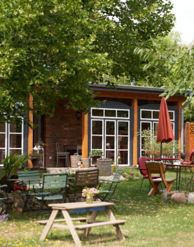 Die Fenster der Veranda hinter Gartenpflanzen